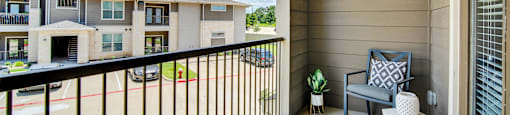 a balcony with a chair and a table