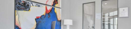 a desk with two chairs and a large painting on the wall
