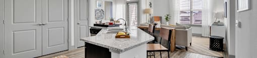 an open kitchen and living room with a large island and a dining room