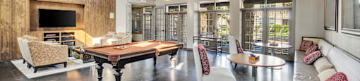 a living room with a pool table and a television
