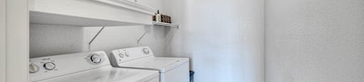 a white laundry room with a washer and dryer and a white washer