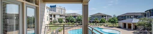 the views of the pool from the balcony of an apartment building with a swimming pool