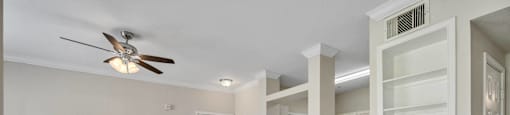 an empty living room with a closet and a ceiling fan