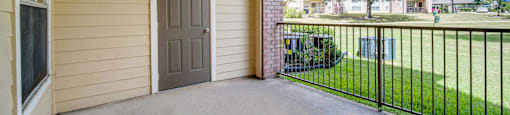 the private patio of a home with a door to the yard