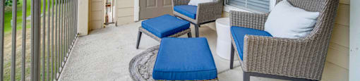 a patio with two chairs and a door to a house