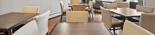 Social room with a dining room with tables and chairs at Victoria Place Apartments