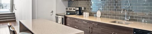 Social room with a kitchen with a counter top and a sink at Victoria Place Apartments