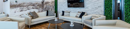 Spacious lounge seating social room with large screen TV at La Voile Broisbriand apartments in Broisbriand, Quebec