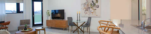 Living room and dining area, with view towards patio door at Bayfield Tower Apartments in Barrie, ON