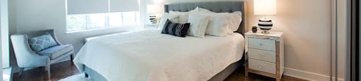Brookbanks Cozy bedroom with large windows and white covers on the bed in Toronto, ON