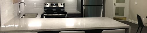 Brookbanks Kitchen in our public social room with three white chairs and a pristine white counter space in Toronto, ON