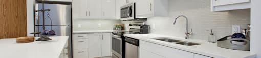 Watson Park Apartments kitchen featuring stainless steel appliances and white cabinets in Guelph, ON