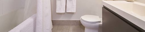 The Duke Vancouver BC A bathroom with a toilet, sink, and full size tub.