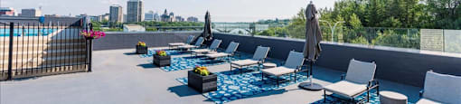 a rooftop terrace with couches and chairs and a view of the city