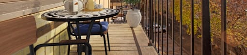 A balcony with a table and chairs is shown.