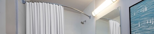 A bathroom with a white toilet, sink, and bathtub with a shower curtain.
