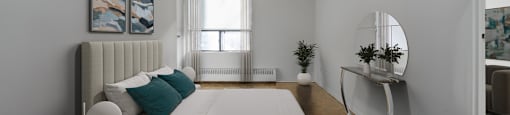 A bedroom with a large bed and a painting on the wall.