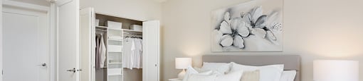Bourg Du Village primary bedroom with double bifold closet featuring built-in storage in Sainte Therese, QC