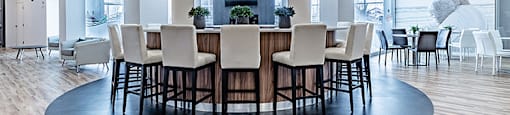 Private kitchen with circular bar in modern social room at La Voile Broisbriand apartments in Broisbriand, Quebec