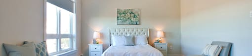Amesbury Gate Bedroom with green painting above bed with white leather headboard in Bedford, NS