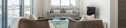 Spacious modern living room with large windows and luxury flooring at Axial Towers apartment in Laval, Quebec