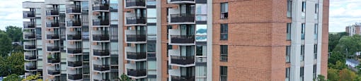 a large apartment building with balconies and trees in front of it