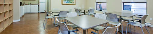 Bay Terrace social room with tables and chairs and kitchenette in Belleville, ON