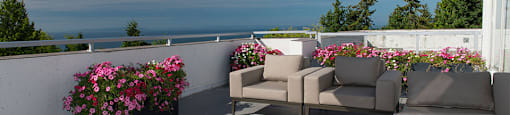 Bayview Gardens Apartments outdoor patio featuring lounge seating and flower planters in White Rock, BC