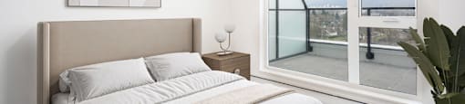 A bedroom with a large bed and a view of the ocean through a glass door at 388 Kaslo East Village.
