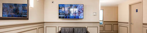 Bourg du Village lobby with seating area and large screen television in Sainte Therese, QC