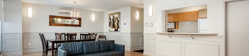 Bourg du Village social room showing seating area with kitchenette and dining area in background in Sainte Therese, QC