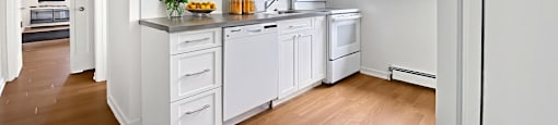 A kitchen with white cabinets and appliances.