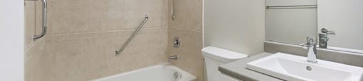 A white toilet sits next to a bathtub in a bathroom.