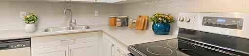 A modern kitchen with a stove top oven and white cabinets.