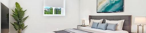 A bedroom with a large bed and a painting on the wall.