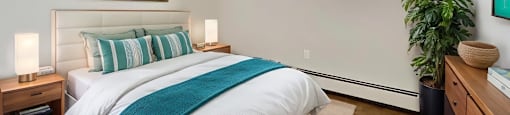 A bedroom with a large bed and a painting on the wall.