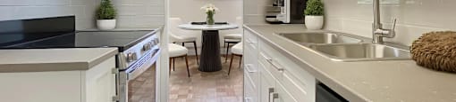 A kitchen with white cabinets and a black countertop.