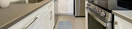 A modern kitchen with white cabinets and stainless steel appliances.
