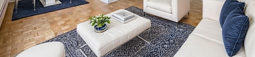 A living room with a white couch, a white coffee table, and a painting on the wall.