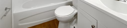 A white bathroom with a toilet, sink, and bathtub.