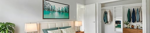 A bedroom with a large bed and a painting on the wall.