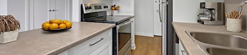 A kitchen with white cabinets and a black refrigerator.