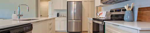 a kitchen with white cabinets and stainless steel appliances