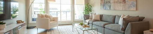 a living room with a gray couch and a white chair