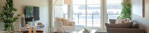 a living and dining area with a glass table and chairs and a large window