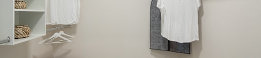 a walk in closet with a white shirt hanging on the wall