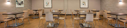 A room with tables and chairs and pictures on the wall.