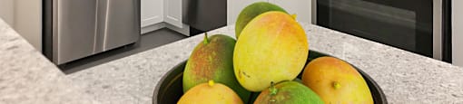 a kitchen with stainless steel appliances and a bowl of fruit