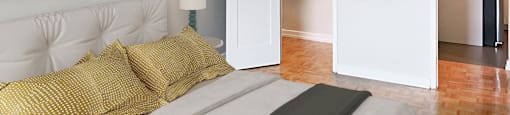 a bedroom with a bed and a closet and a painting on the wall