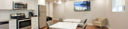 Cedarwoods Tower in Kitchener, ON social room with stainless steel appliances and dining set